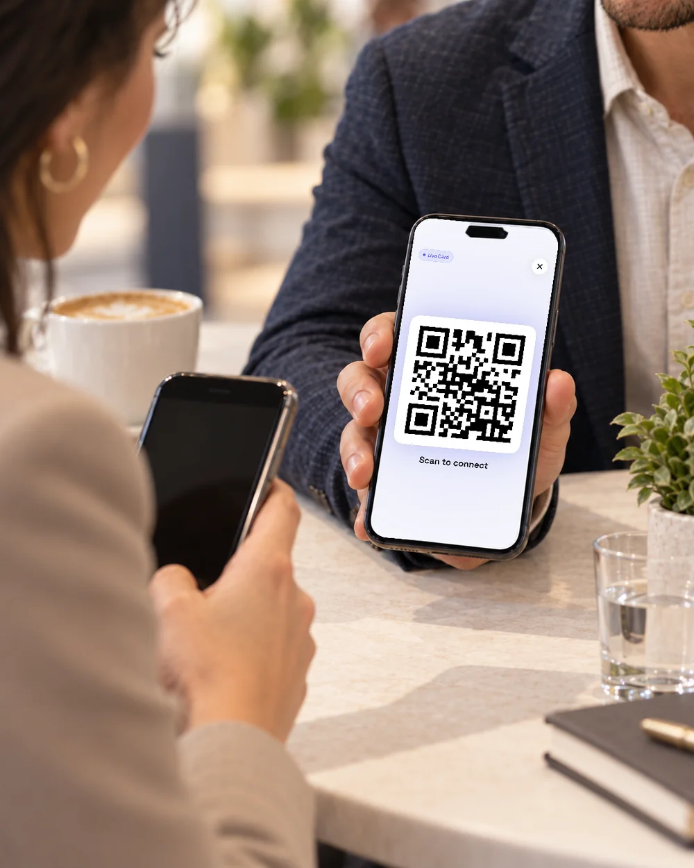 Sharing a digital business card across the table at a client meeting.